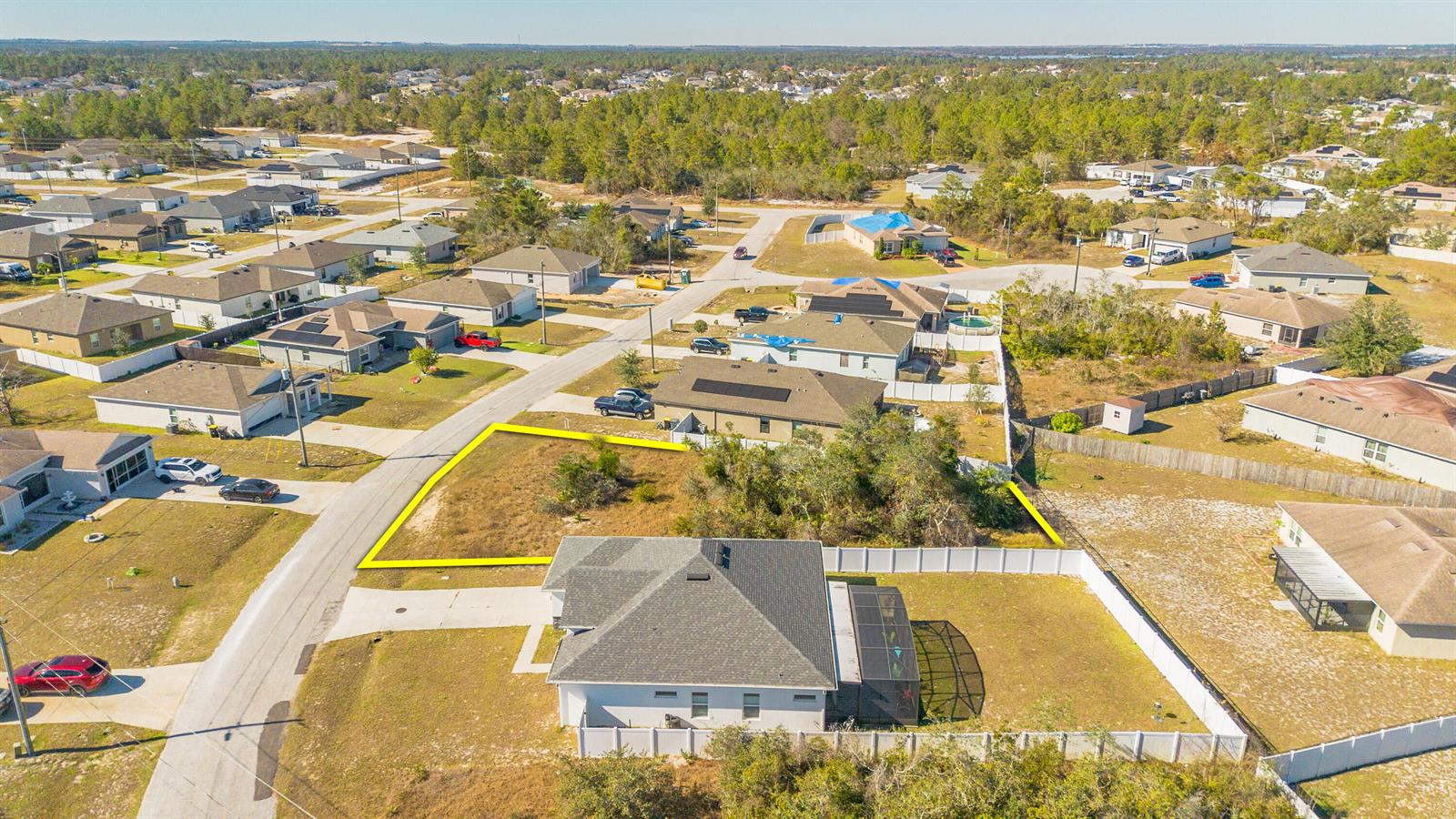 An aerial view shows a vacant residential lot outlined in yellow next to a house — 19 Orchid Court, FL 34759, FL