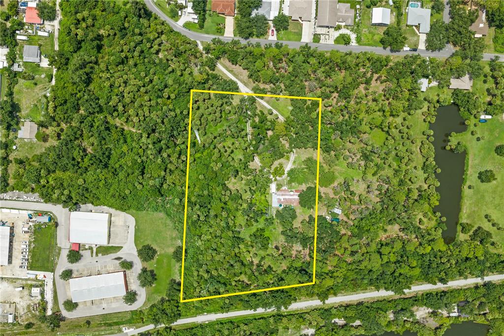 This aerial view shows a rectangular property lot outlined in yellow containing a single house — 1210 TWIN LAKES AVENUE, NOKOMIS, FL