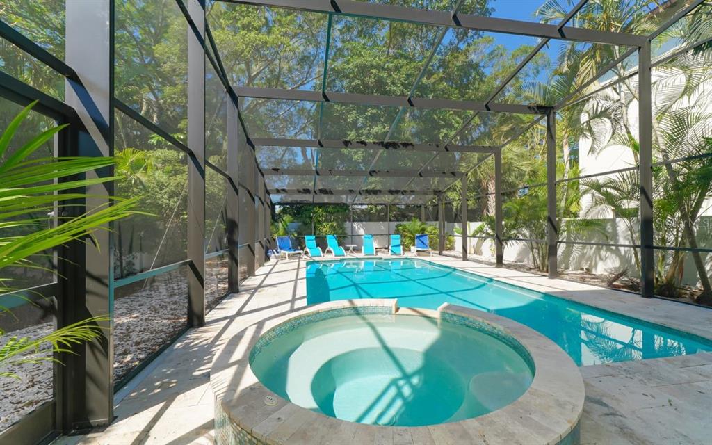 A screened-in pool area features a circular hot tub, a rectangular swimming pool, and lounge chairs — 228 VAN BUREN DRIVE, SARASOTA, FL