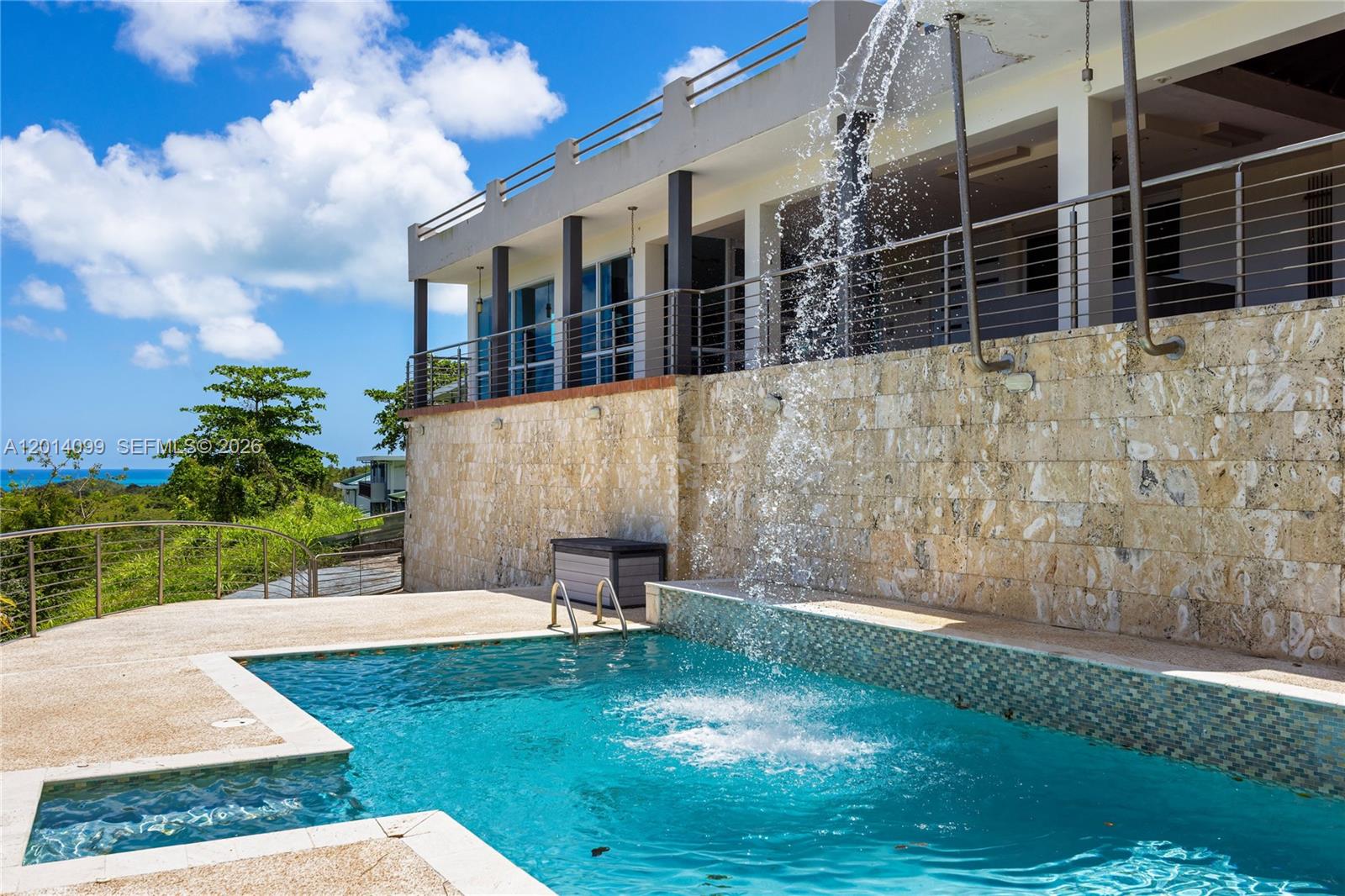 A covered outdoor patio features tiled flooring, a wooden ceiling, and a panoramic ocean view — 95 N Melao, PR 00773, PR
