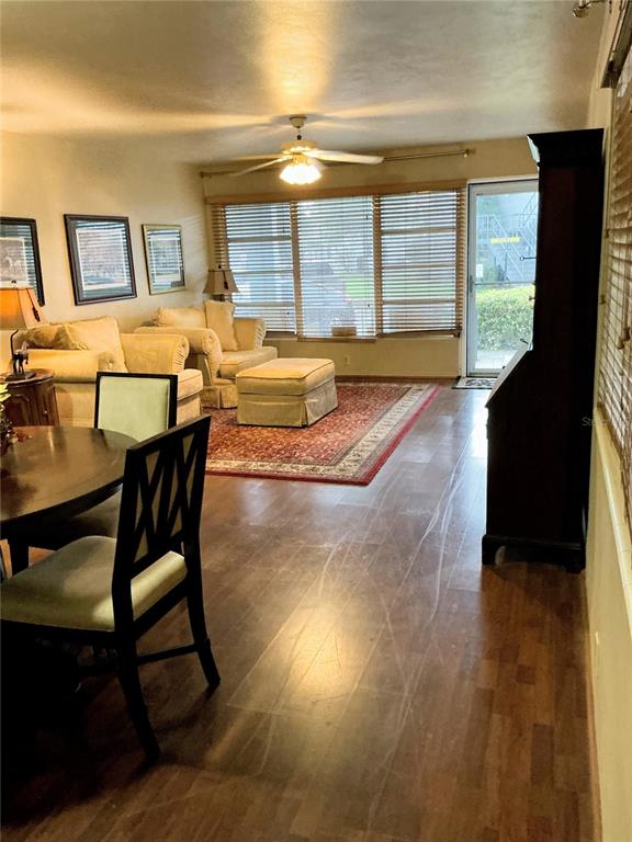 A living room with wood-look flooring, a ceiling fan, and a seating area with furniture — 4300 58TH STREET N UNIT 1801, KENNETH CITY, FL
