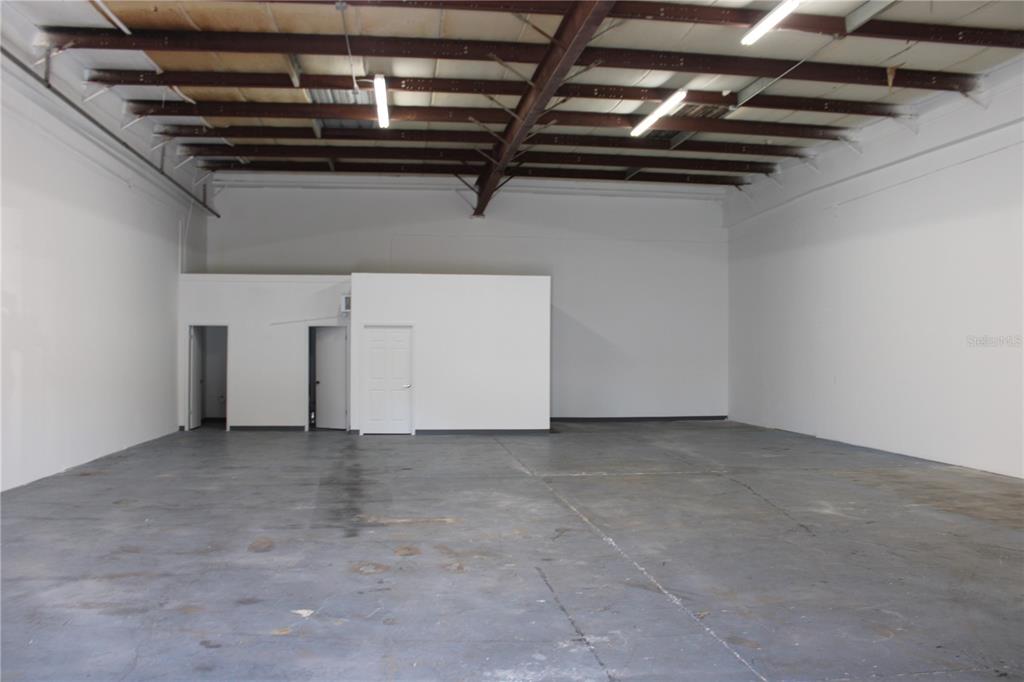 An empty industrial warehouse space features white walls, a concrete floor, and exposed ceiling beams — 1400 L AND R INDUSTRIAL BOULEVARD Bldg. A, TARPON SPRINGS, FL