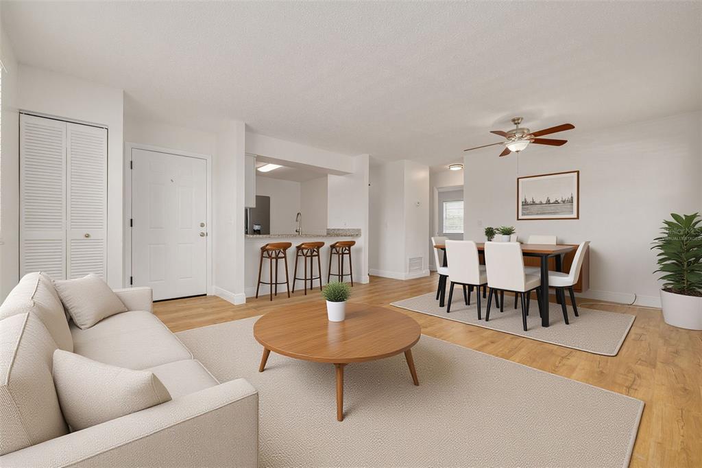 A living room and dining area with light wood floors, white walls, and neutral furniture — 5715 S DALE MABRY HIGHWAY UNIT C, TAMPA, FL
