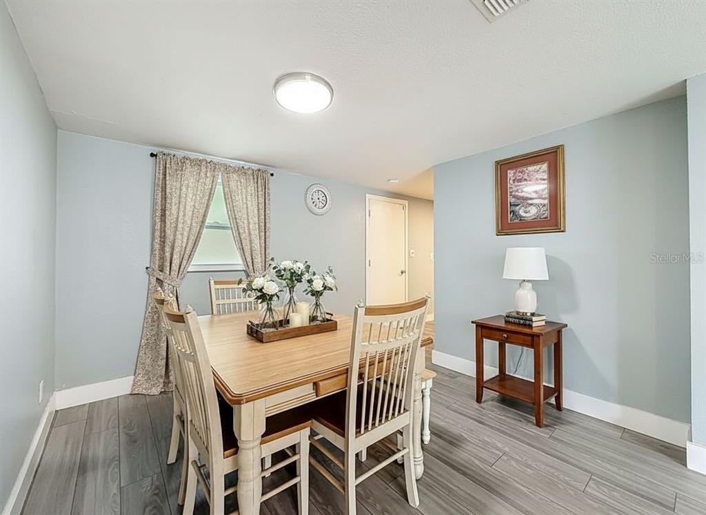 A dining room features light blue walls, wood-look flooring, a wooden table, and four chairs — 544 MERCURY AVENUE, ORLANDO, FL