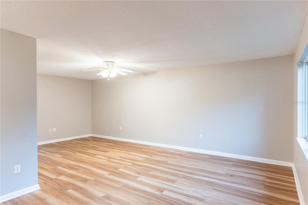 An empty room with light-colored walls, wood-look flooring, and a ceiling fan — 501 SW 75TH STREET UNIT D13, GAINESVILLE, FL