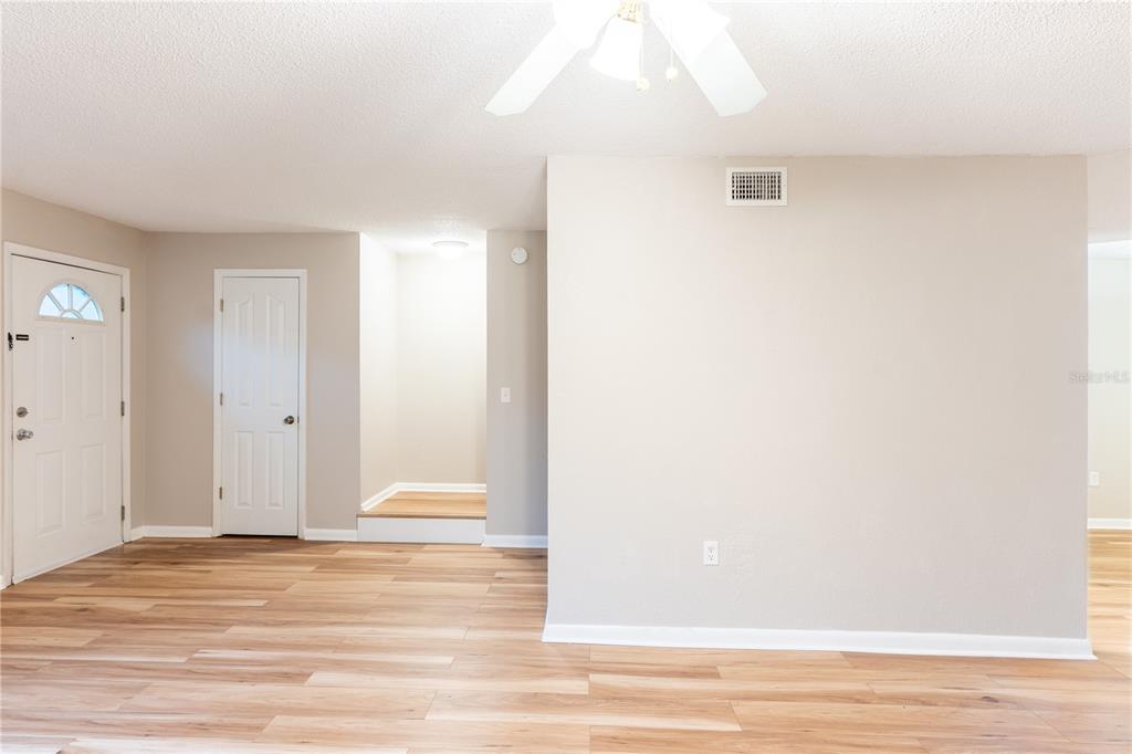An interior view of a room with light wood-look flooring, white walls, and a ceiling fan — 501 SW 75TH STREET UNIT D13, GAINESVILLE, FL
