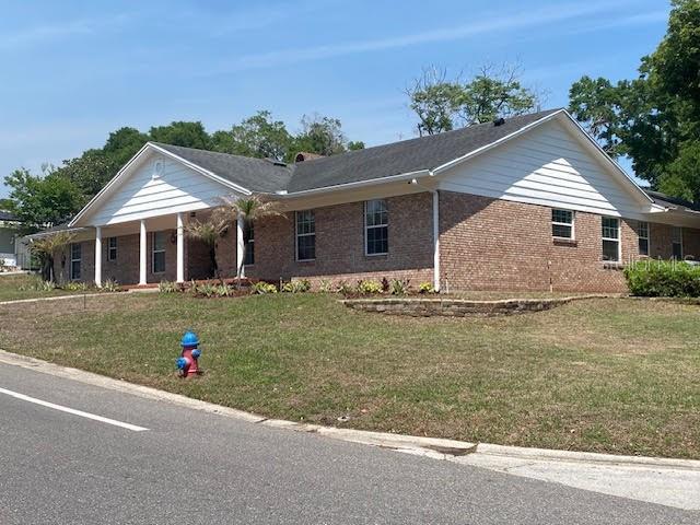 A single-story brick house with a white-columned porch sits behind a grassy lawn — 1449 ERROL PARKWAY, APOPKA, FL