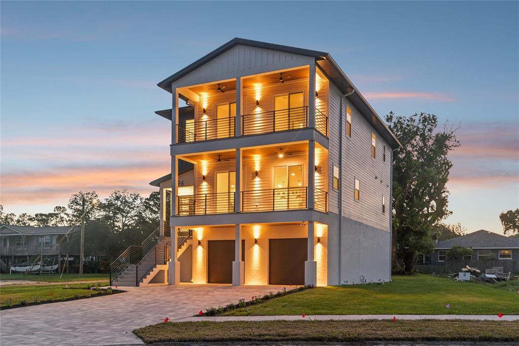 A three-story elevated house with two levels of balconies and a ground-level garage — 96 SHORE DRIVE, TARPON SPRINGS, FL