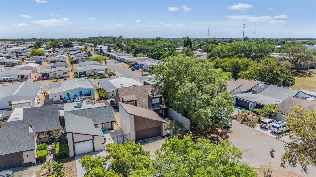 An aerial view shows a residential neighborhood with several houses, trees, and paved streets — 7300 BELLOWS FALLS LANE, HUDSON, FL