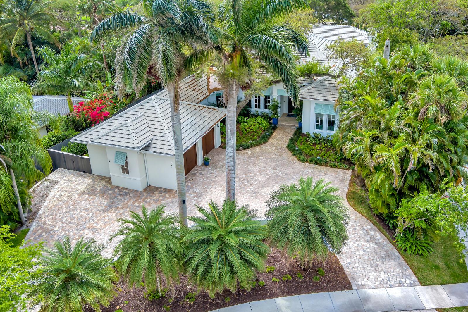 An aerial view shows a white house with a paved driveway and lush tropical landscaping — 544 Live Oak Road, Vero Beach FL 32963, VERO BEACH, FL