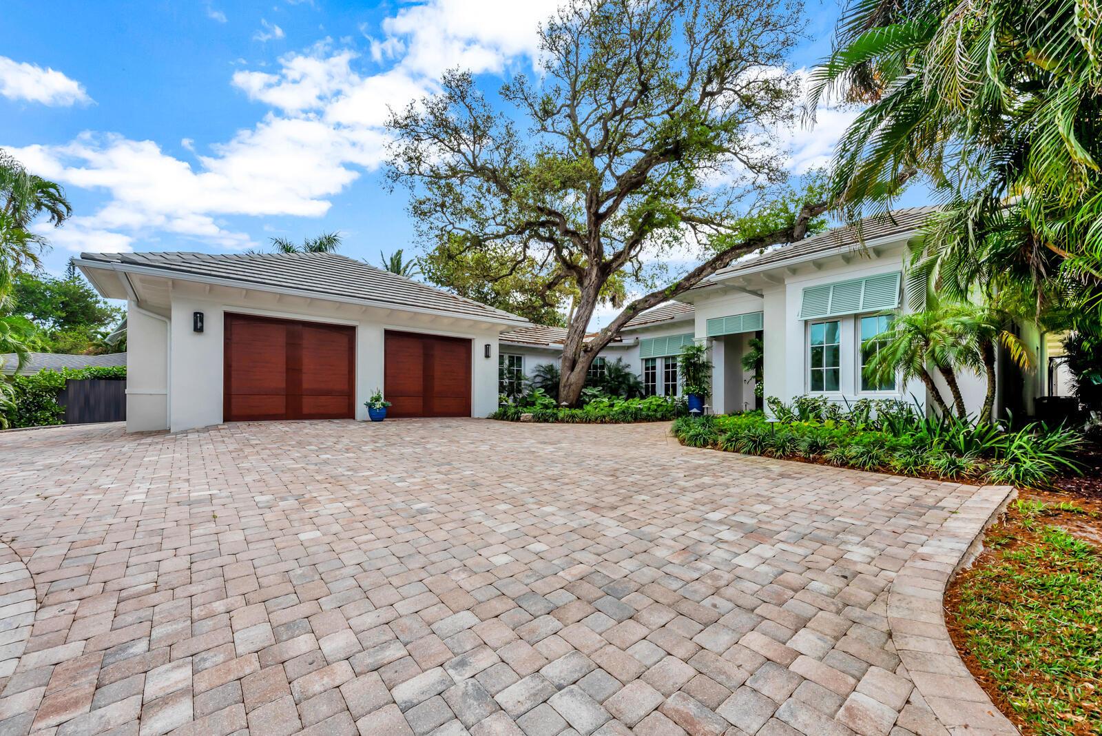 A single-story house with a paver driveway, two wooden garage doors, and a large tree — 544 Live Oak Road, Vero Beach FL 32963, VERO BEACH, FL