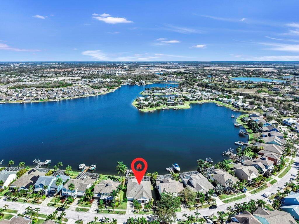 An aerial view shows a waterfront house with a pool cage in a residential neighborhood — 5237 BRIGHTON SHORE DRIVE, APOLLO BEACH, FL