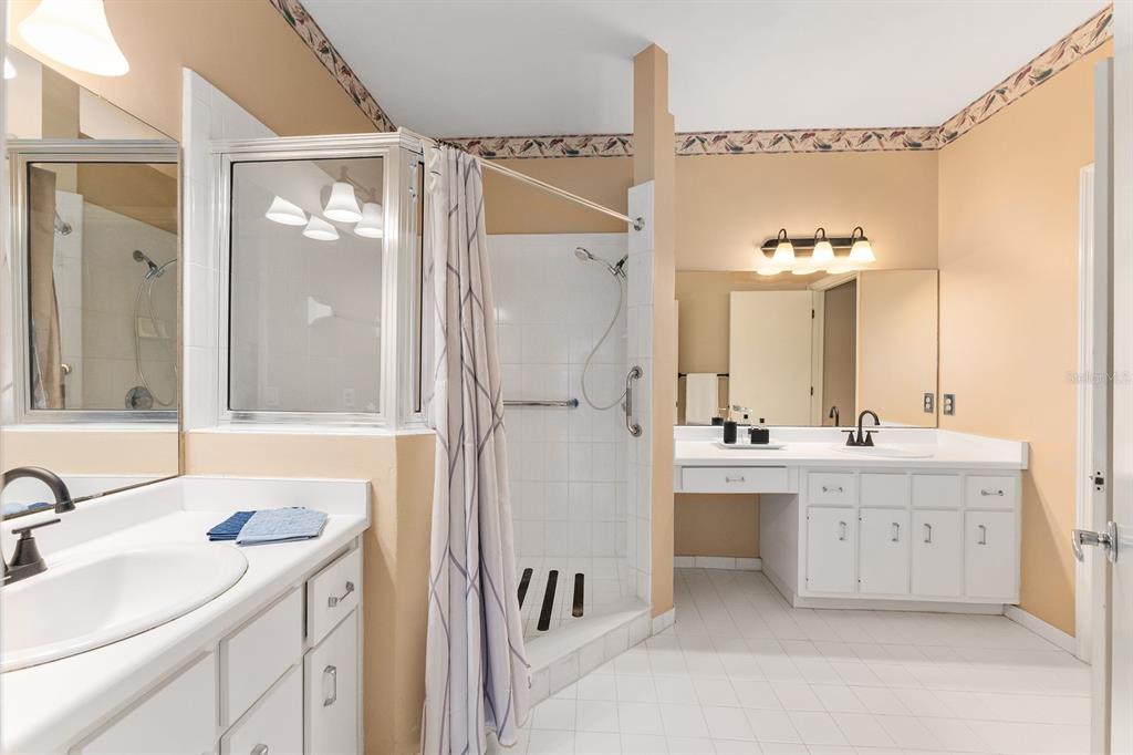 A bathroom features dual white vanities, a tiled walk-in shower, and beige walls — 3725 NW 58TH PLACE, GAINESVILLE, FL