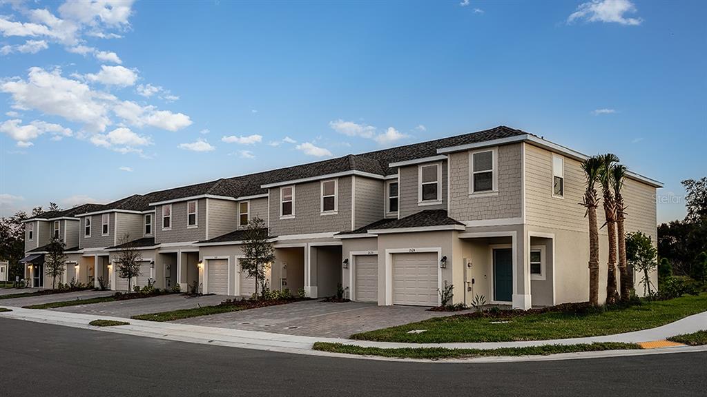 A row of multi-story townhouses with beige siding, shingled roofs, and attached garages — 2978 CANARY AVENUE, DAVENPORT, FL
