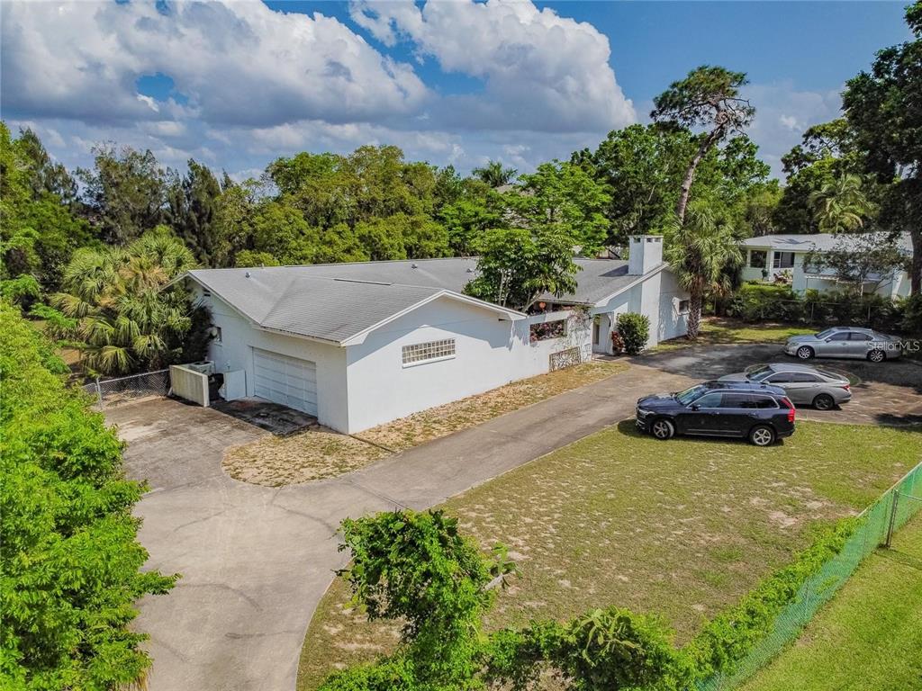 An aerial view of a white single-story house with a driveway and parked cars — 425 CRAIG DRIVE, TARPON SPRINGS, FL