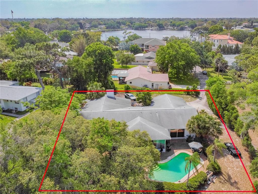 An aerial view shows a house with a swimming pool surrounded by trees and landscaping — 425 CRAIG DRIVE, TARPON SPRINGS, FL