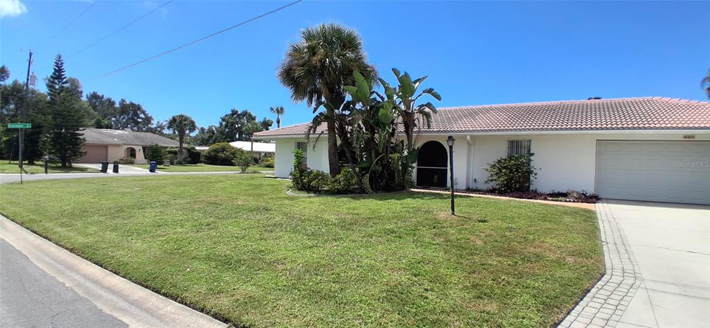 A single-story house with a white exterior, a tiled roof, and a front-facing garage — 441 RUBENS DRIVE E, NOKOMIS, FL