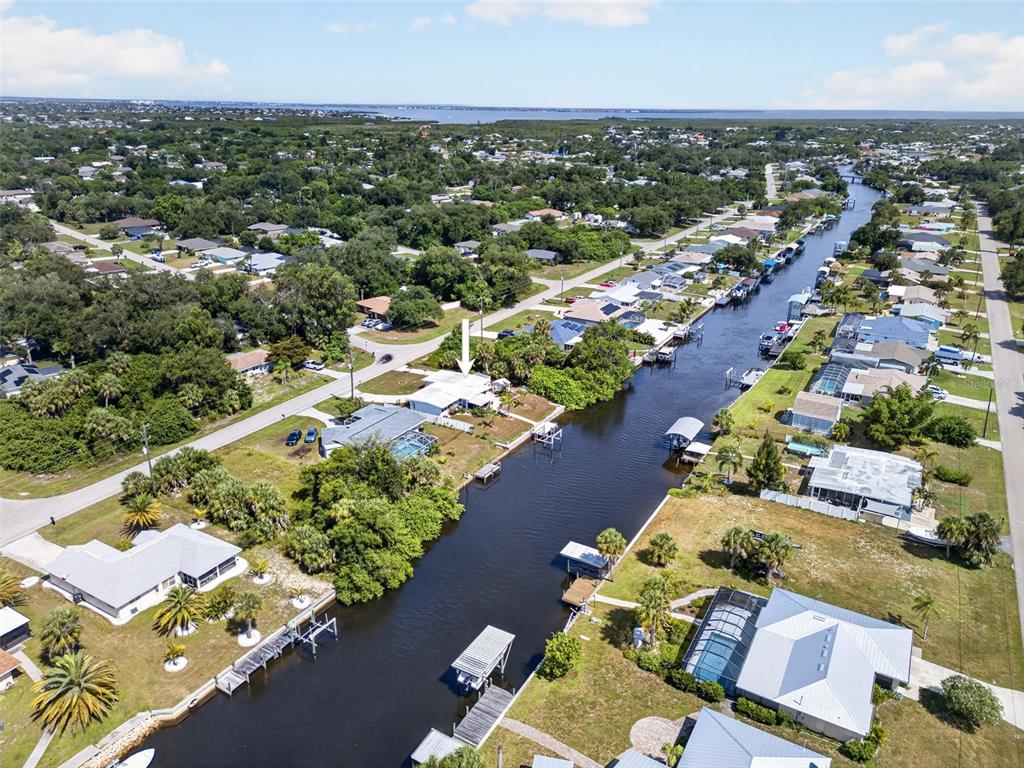 An aerial view shows a waterfront house with a dock along a canal — 3349 ROCK CREEK DRIVE, PORT CHARLOTTE, FL