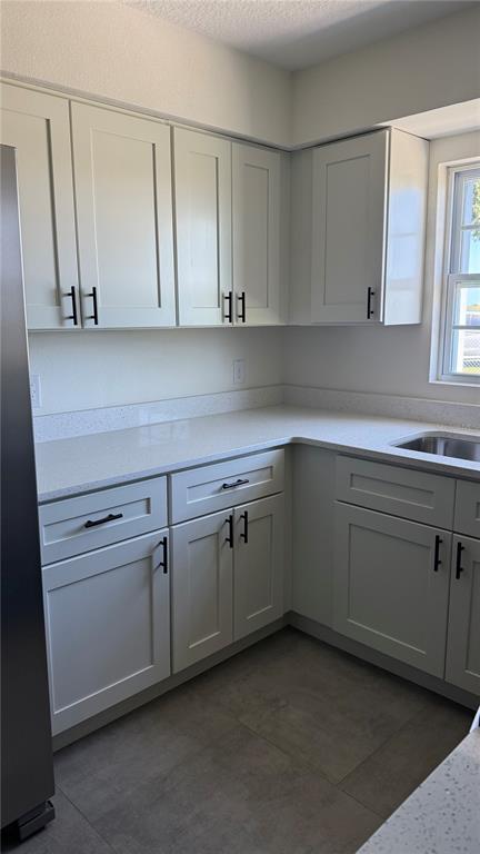 A kitchen with white shaker cabinets, light countertops, and dark hardware — 606 RIDGEWOOD AVENUE, DUNDEE, FL