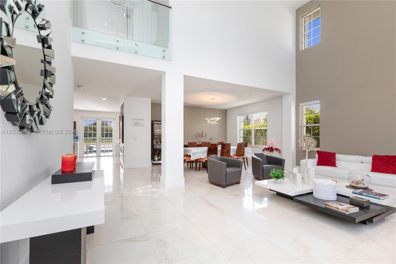 A bright, open-concept living and dining area features high ceilings, white tile floors, and furniture — 2505 Hunters Run Way, Weston FL 33327, WESTON, FL
