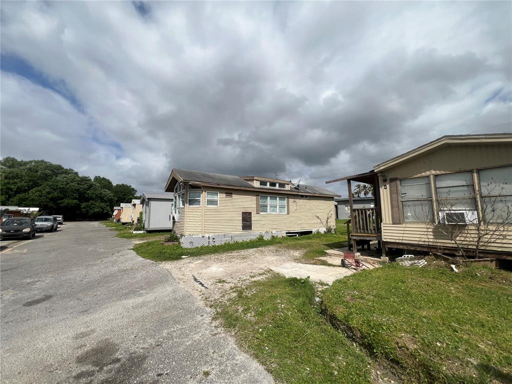 A row of mobile homes sits along a paved road under a cloudy sky — 15992 W COLONIAL DRIVE, OAKLAND, FL