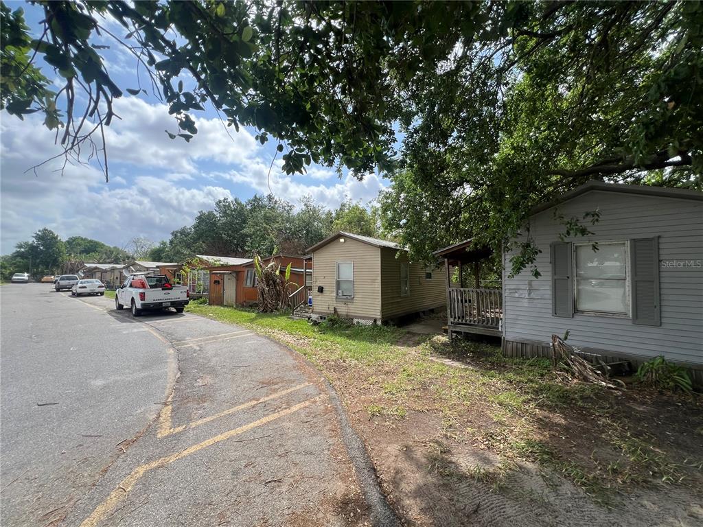 A street view shows several small, single-story houses with a white truck parked nearby — 15992 W COLONIAL DRIVE, OAKLAND, FL