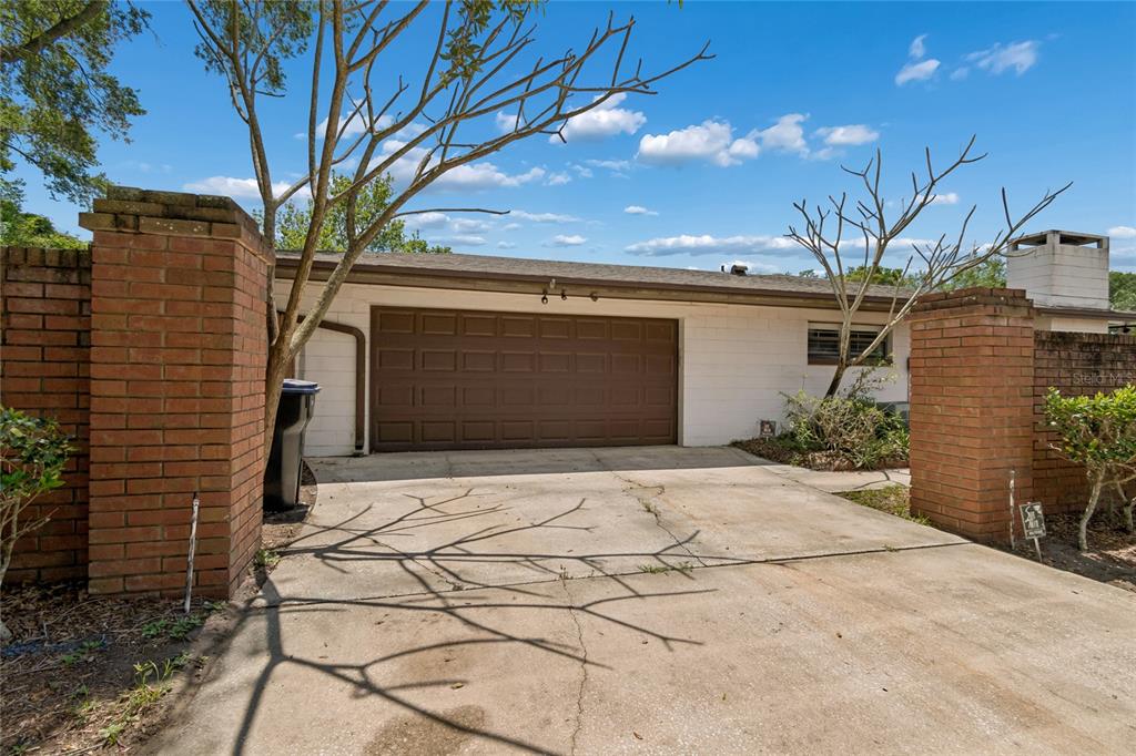A single-story ranch-style house with a brick facade, brown shutters, and a large front lawn — 4801 BIG OAKS LANE, ORLANDO, FL