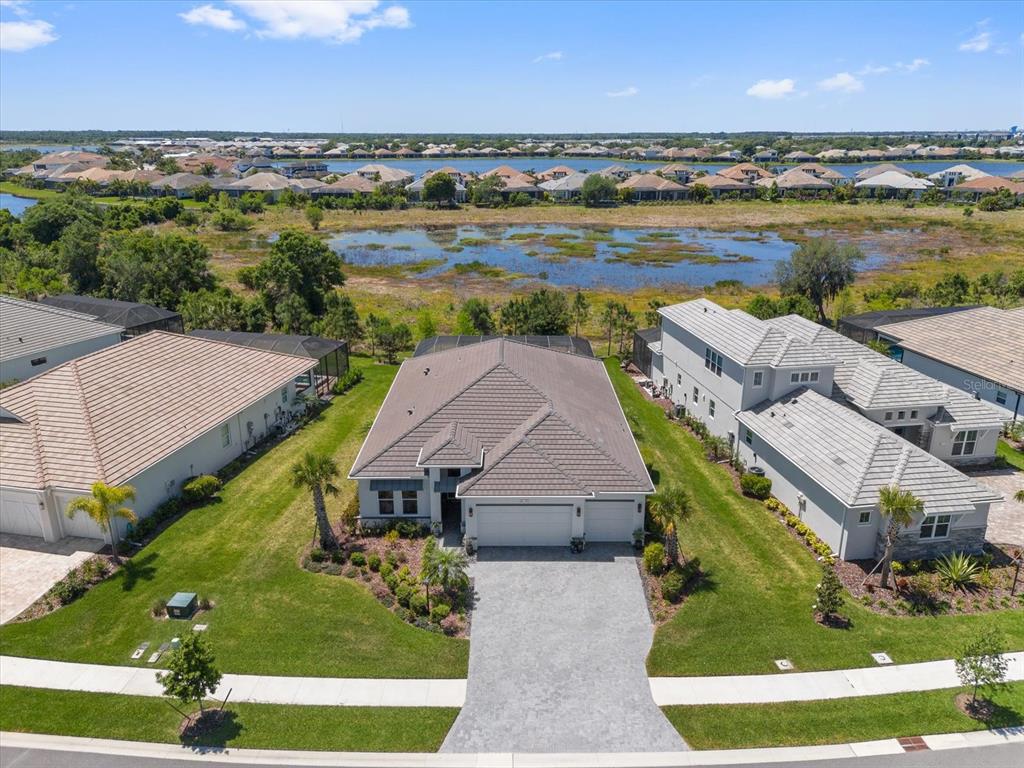 An aerial view shows a single-story house with a tiled roof and a paved driveway — 729 TAILWIND PLACE, SARASOTA, FL