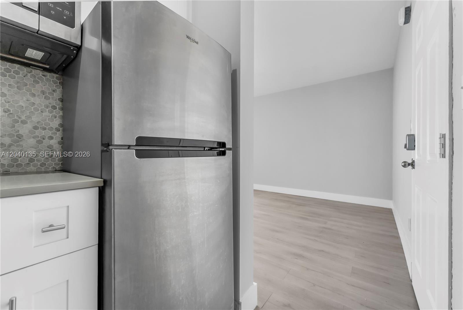 A stainless steel refrigerator stands next to white cabinets and a gray tiled backsplash — 6647 SW 59th Pl # 207, South Miami FL 33143, SOUTH MIAMI, FL