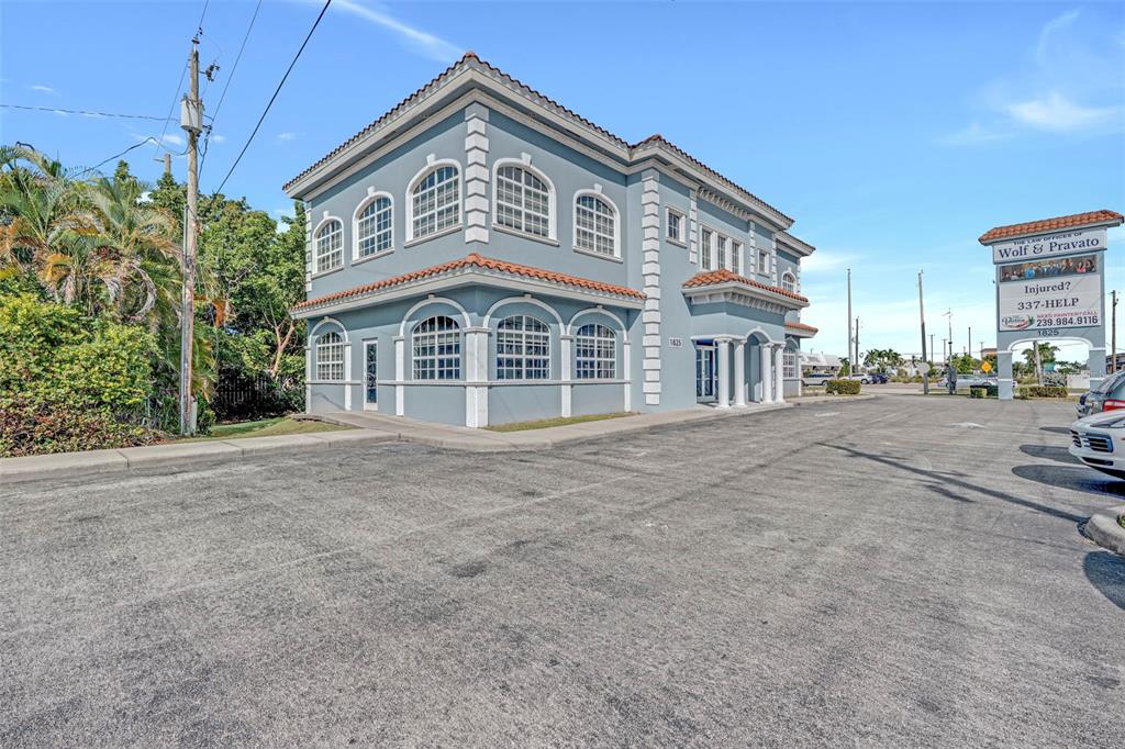 A two-story blue commercial building with arched windows and a parking lot in front — 1825 COLONIAL BOULEVARD, FORT MYERS, FL
