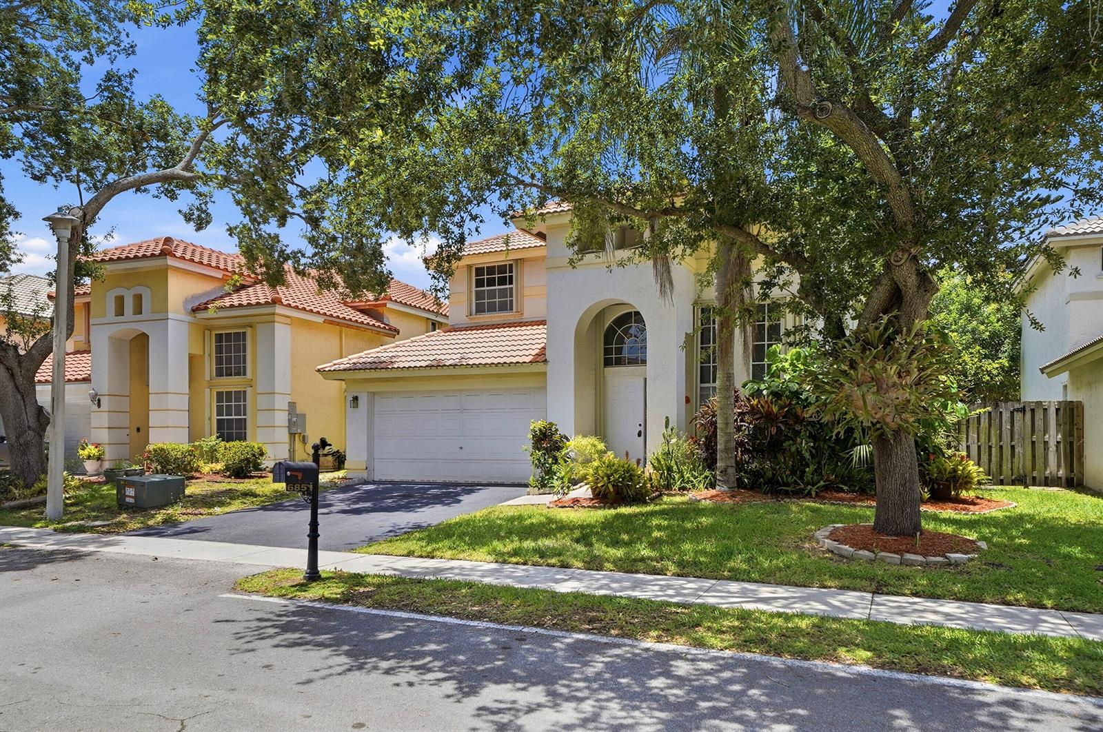 A two-story house with a white stucco facade, tile roof, and a two-car garage — 6851 NW 27th Street, Margate FL 33063, MARGATE, FL