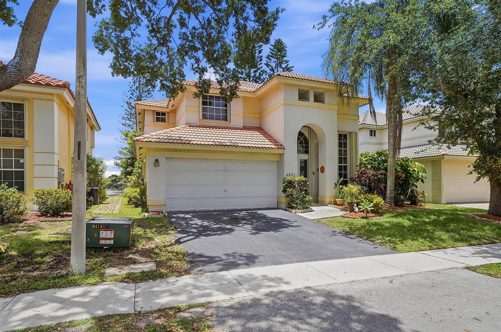 A two-story stucco house with a tile roof and a two-car garage — 6851 NW 27th Street, Margate FL 33063, MARGATE, FL