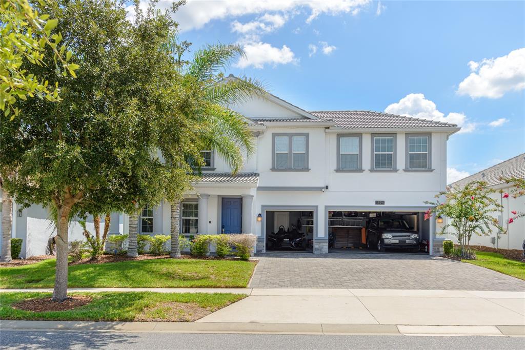 A two-story white house with a blue front door and a two-car garage — 1394 OLYMPIC CLUB BOULEVARD, CHAMPIONS GATE, FL