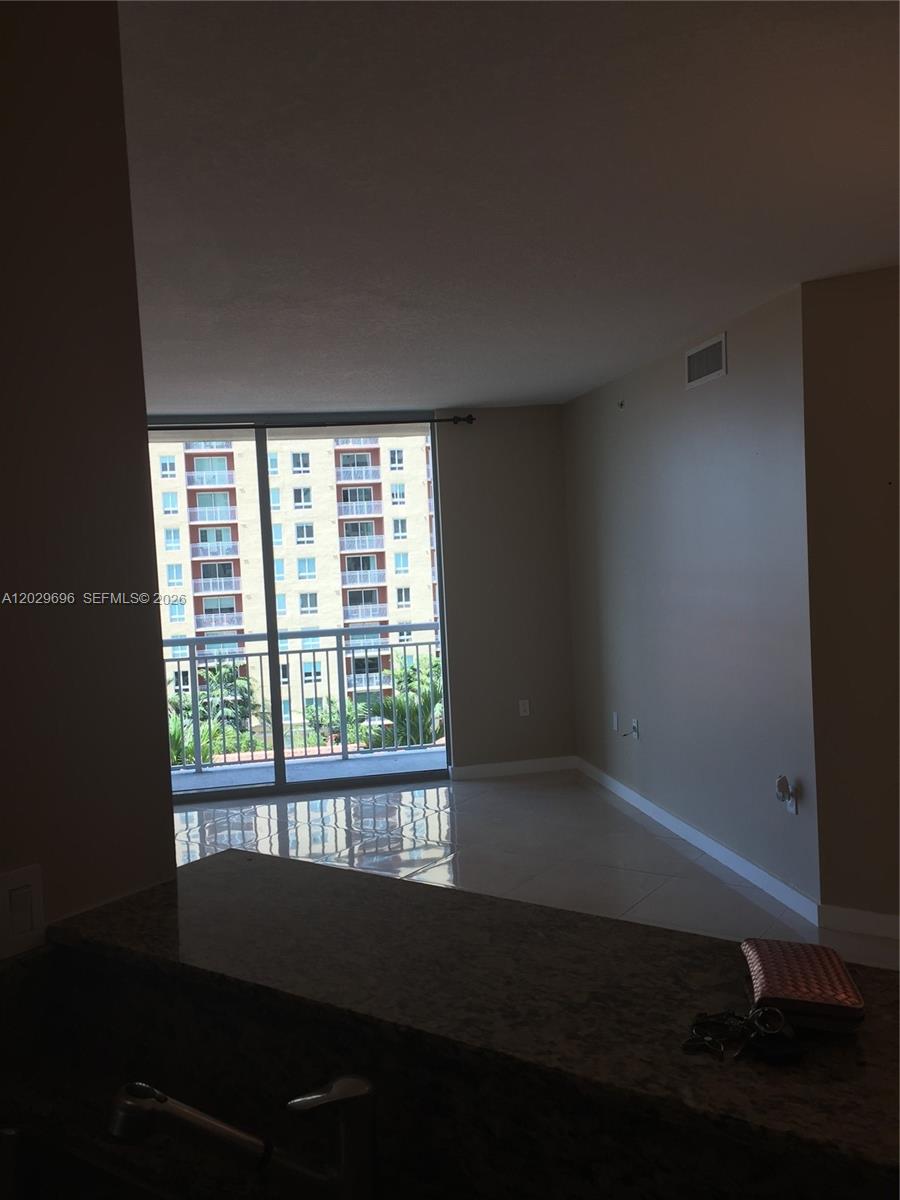 An interior view of a living area with tile floors, a balcony, and a countertop — 9066 SW 73rd Ct # 907, Miami FL 33156, MIAMI, FL