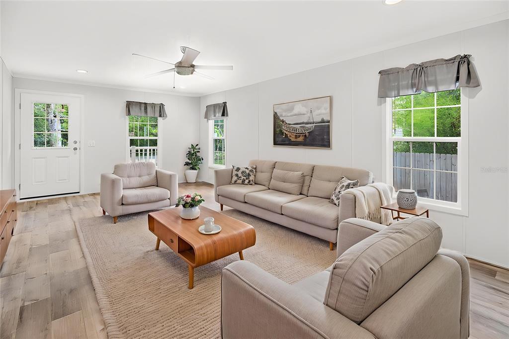 A living room features a beige sofa, two armchairs, a wooden coffee table, and light flooring — 17475 TAVERN ROAD, BROOKSVILLE, FL