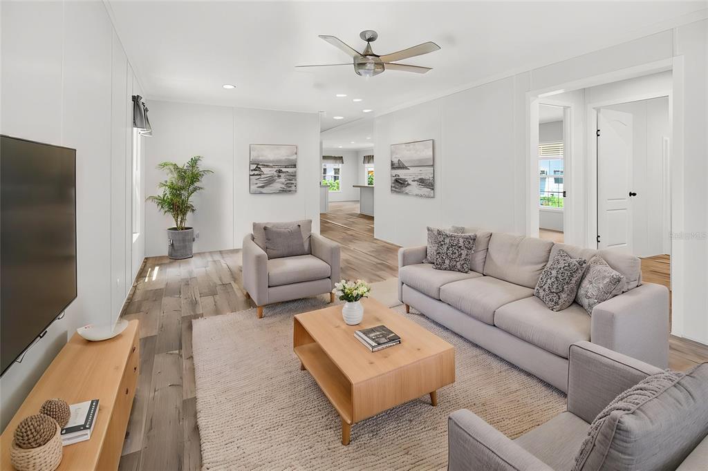 A living room features light wood flooring, a gray sofa, two armchairs, and a coffee table — 17475 TAVERN ROAD, BROOKSVILLE, FL