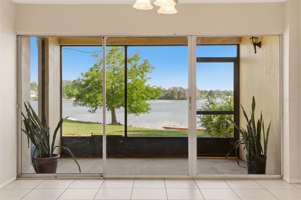 A view of a lake through a large sliding glass door in a tiled room — 574 ORANGE DRIVE UNIT 76, ALTAMONTE SPRINGS, FL