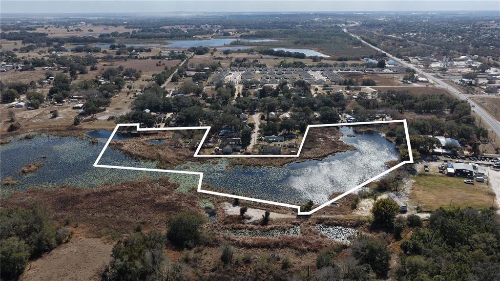 An aerial view shows a large, irregularly shaped pond outlined in white — 800 US HIGHWAY 17 92 S, DAVENPORT, FL