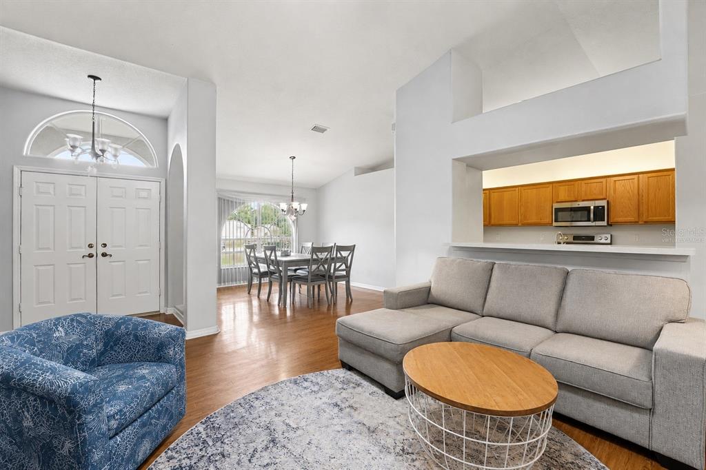 A living room with a sectional sofa, a dining area, and a kitchen pass-through window — 12606 LITEWOOD DR, HUDSON, FL