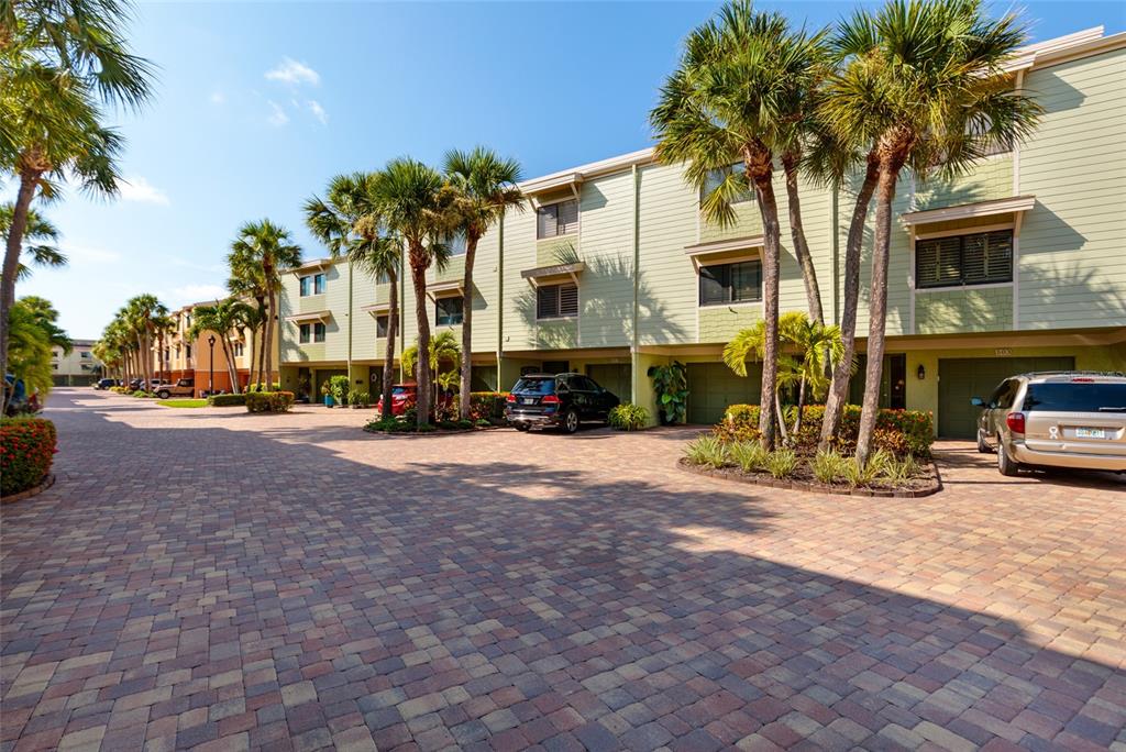 A hallway features a wooden staircase, tile flooring, a console table, and framed wall art — 505 SANDY HOOK ROAD UNIT 505, TREASURE ISLAND, FL