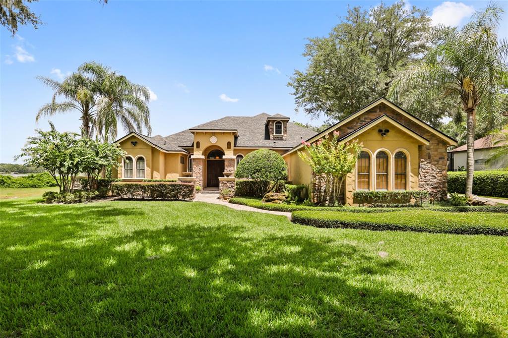 A single-story house with a stucco exterior, stone accents, and a large front lawn — 863 CARDINAL POINTE COVE, SANFORD, FL