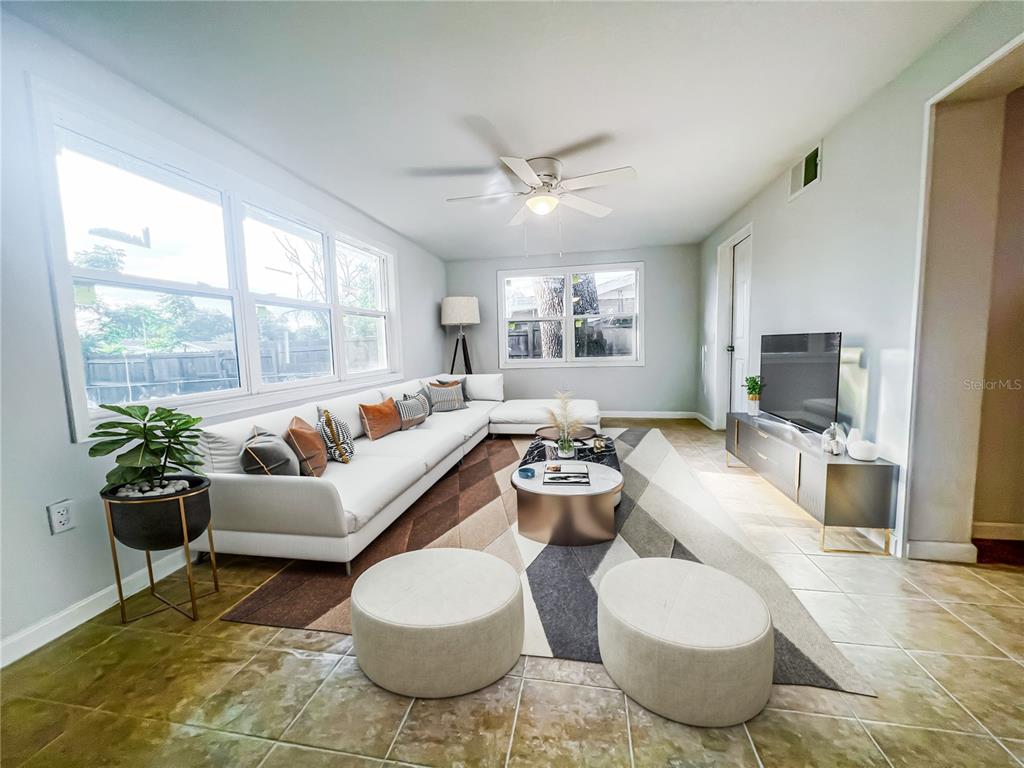 A living room features a large white sectional sofa, a geometric rug, and tile flooring — 137 LOWELL ROAD, WINTER HAVEN, FL