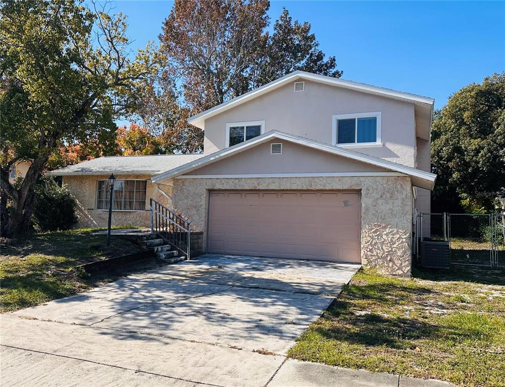 A two-story house with a stone-accented facade, a two-car garage, and a concrete driveway — 1649 E SHANGRI LA DRIVE, DAYTONA BEACH, FL