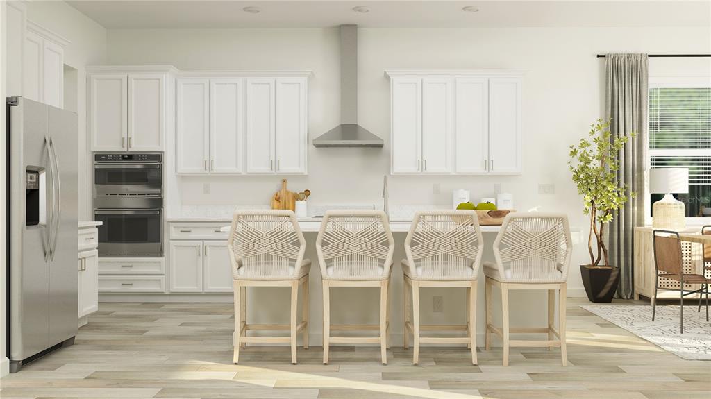 This is a rendering of a modern kitchen with white cabinets, stainless appliances, and island seating — 9315 MINNOW RAY DRIVE, LAND O LAKES, FL