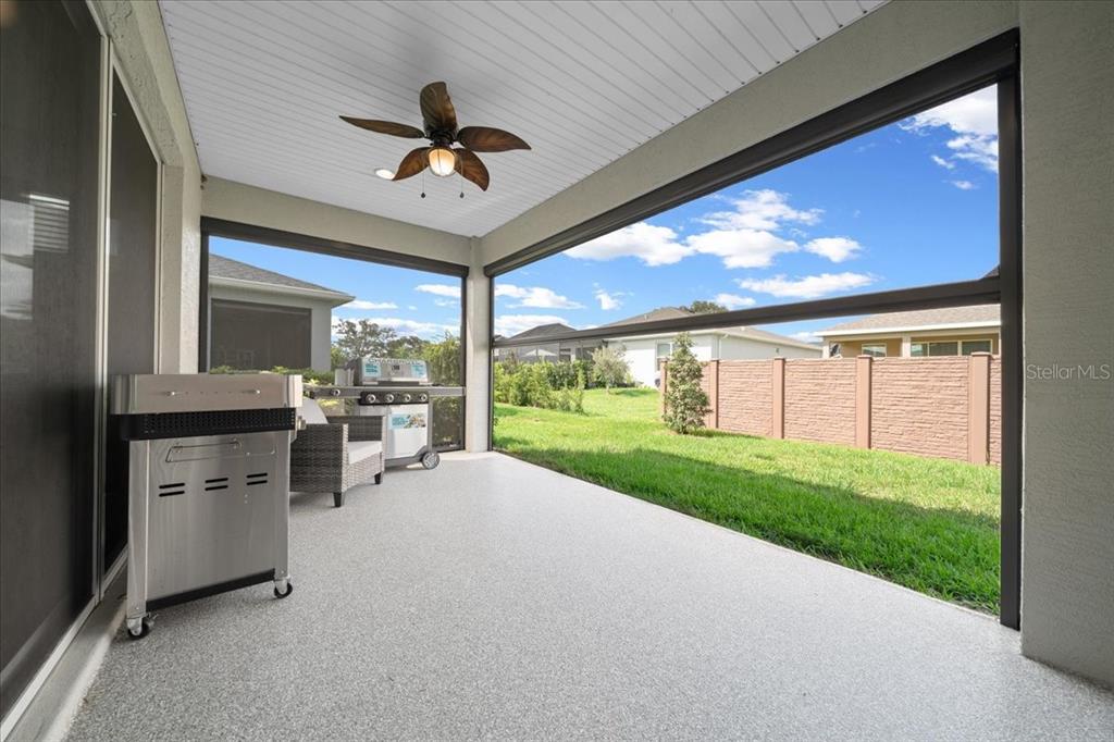 A covered patio with a ceiling fan, concrete flooring, and a view of the backyard — 4378 NW 54TH TERRACE, OCALA, FL
