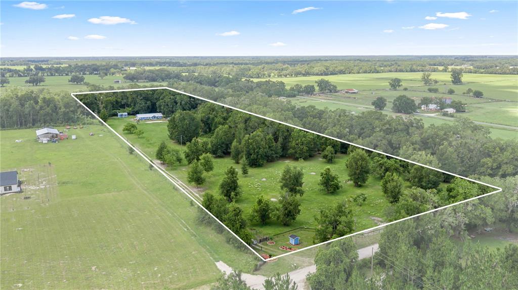 An aerial view shows a large, tree-filled residential lot with a house and outbuildings — 1890 NW 167TH PLACE, TRENTON, FL