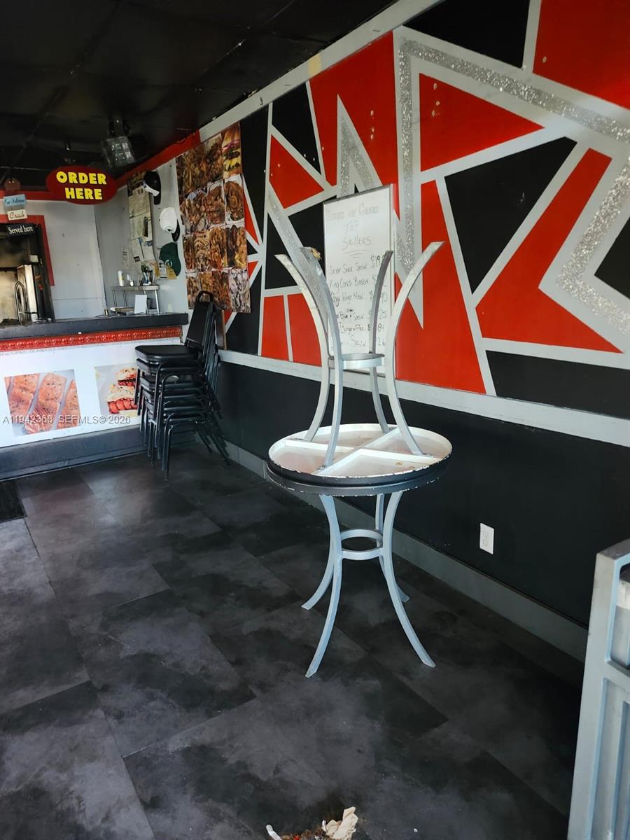 A restaurant interior features a counter, stacked chairs, and a table with an inverted chair — 10951 NW 27th Ave, Miami FL 33167, MIAMI, FL