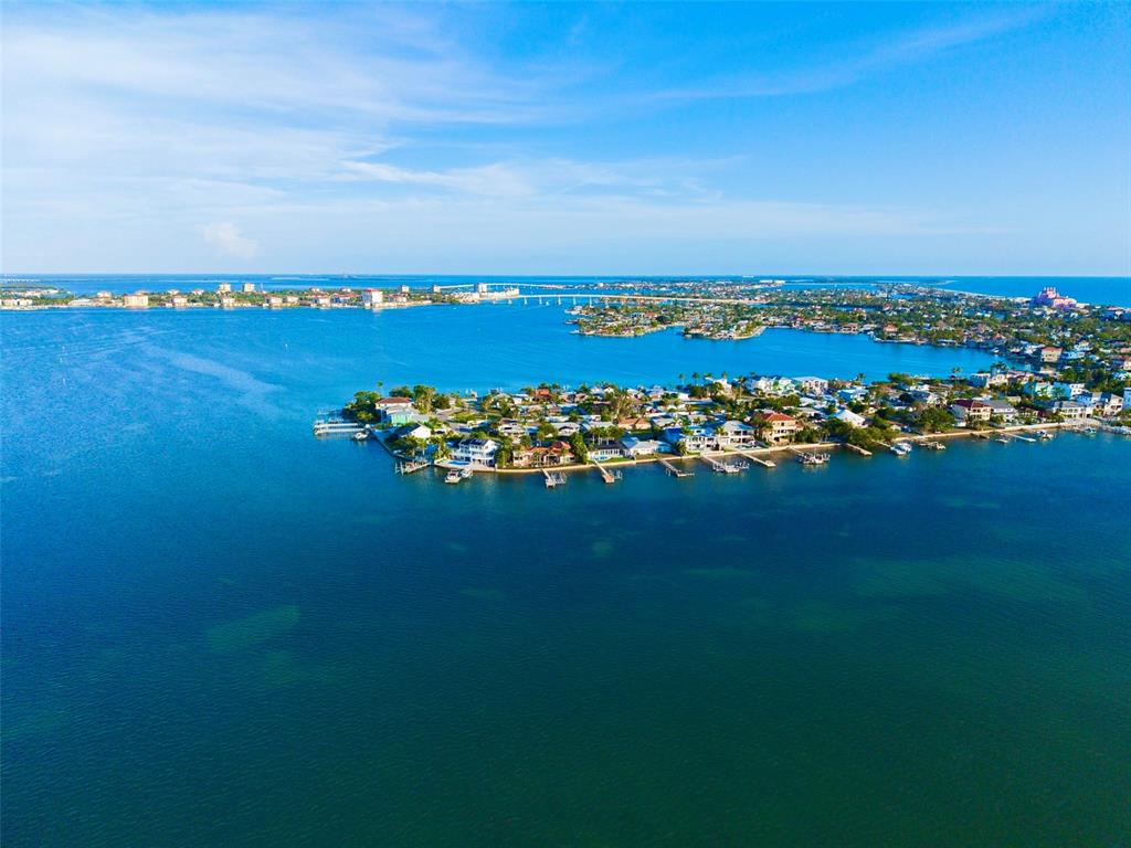 An aerial view of a residential neighborhood on a peninsula surrounded by blue water — 1015 BOCA CIEGA ISLE DRIVE, ST PETE BEACH, FL
