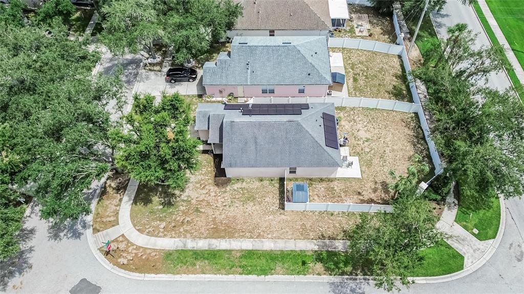 An aerial view shows two adjacent houses with solar panels on the roof and fenced yards — 346 SUMMER SAILS DRIVE, VALRICO, FL