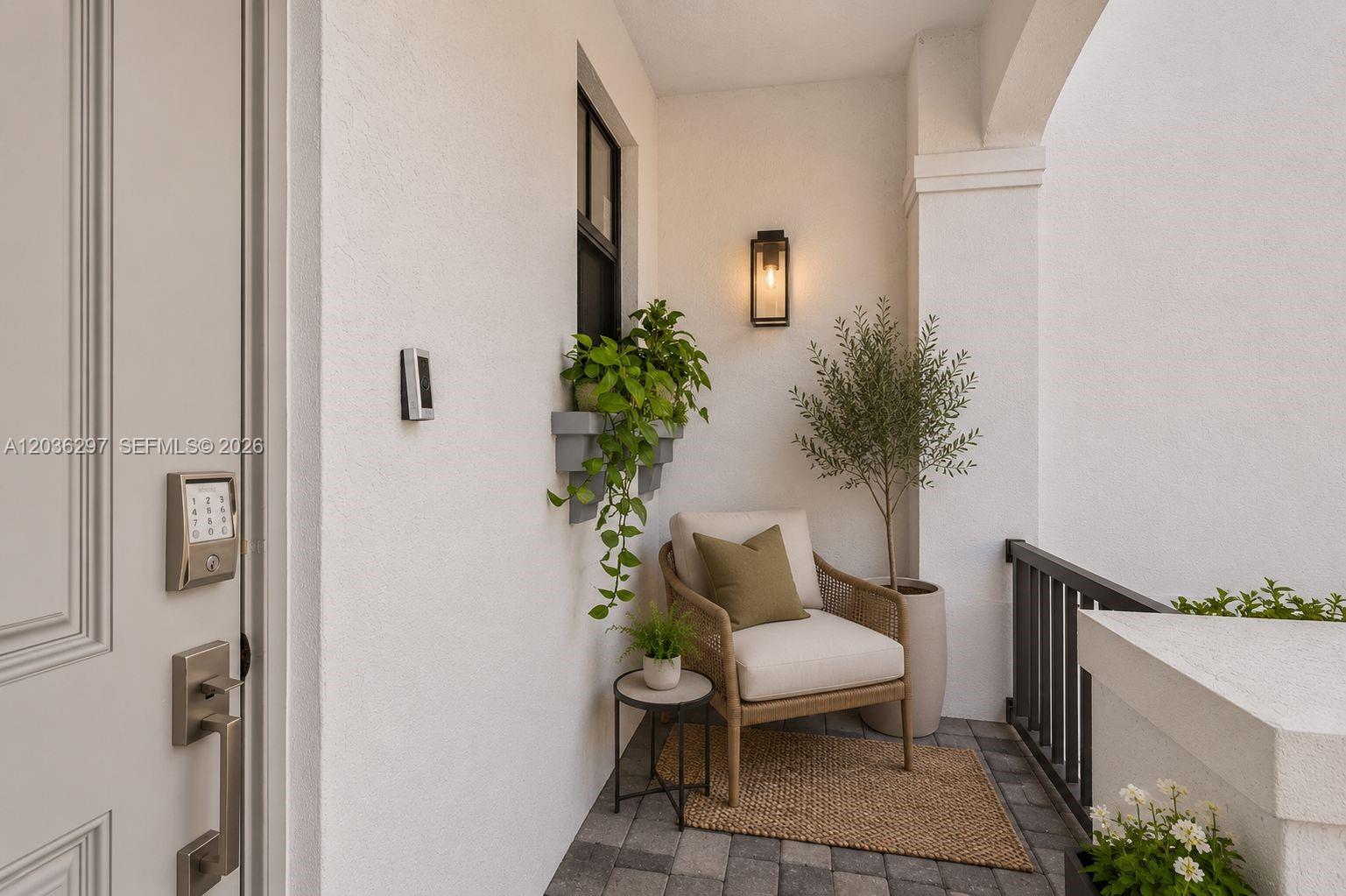 A small, covered outdoor entryway features a chair, potted plants, and a keypad door lock — 592 NW 203rd Ter, Miami Gardens FL 33169, MIAMI GARDENS, FL